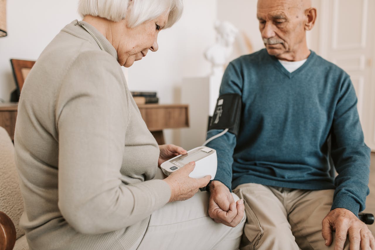 about-03 Senior couple at home using a sphygmomanometer to monitor blood pressure, promoting elderly health care.