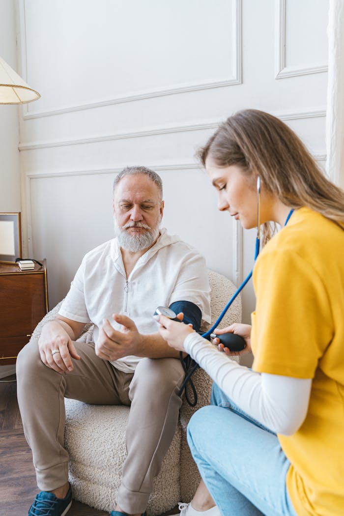 about-01 A healthcare professional checks an elderly man's blood pressure in a cozy room.